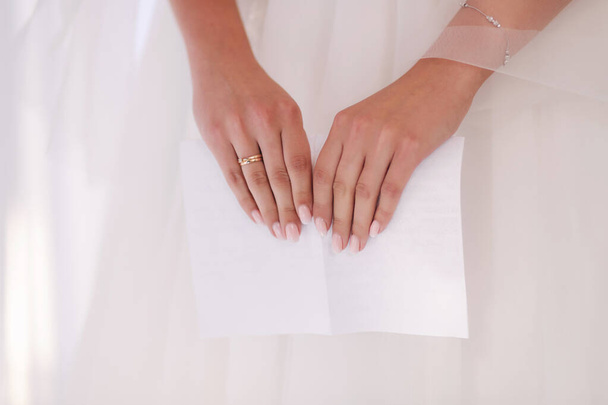 Zblízka nevěsta držet kus papíru se svatebním slibem - Fotografie, Obrázek