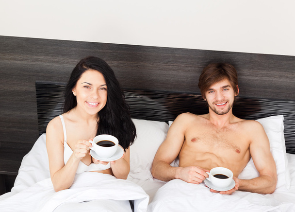 Young couple drink coffee in bed - Photo, Image