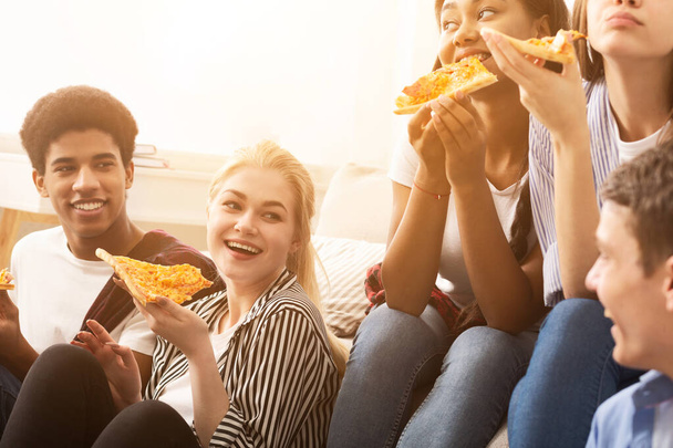 Различные друзья едят пиццу и разговаривают на домашней вечеринке
 - Фото, изображение