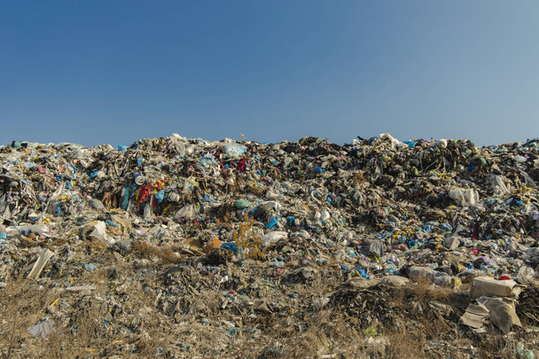 τεράστια χωματερή λόφο σκουπίδια και μπλε ουρανό κενό χώρο αντίγραφο για το κείμενο ή την επιγραφή σας, την περιβαλλοντική ρύπανση και την παγκόσμια οικολογική καταστροφή έννοια φωτογραφία  - Φωτογραφία, εικόνα