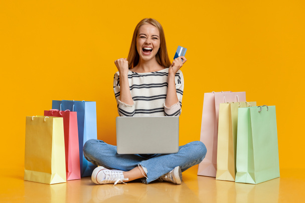 Beautiful girl excited after successful online shopping. - 写真・画像