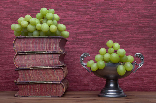 Renascimento, copo de estanho livros antigos e uvas
 - Foto, Imagem