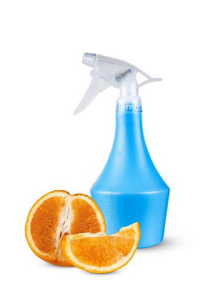 Orange against the background of a plastic bottle with a spray. - Foto, Imagen