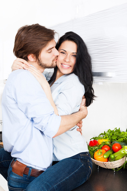 Couple kissing at their kitchen - Фото, изображение