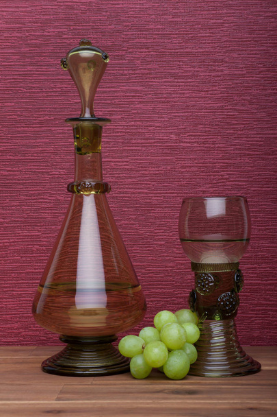 Αναγέννηση, Rummer κρασί γυαλί και μπουκάλι με πράσινα σταφύλια - Φωτογραφία, εικόνα