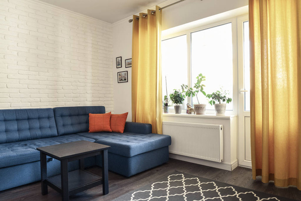 Habitación familiar limpia con sofá azul
 - Foto, Imagen