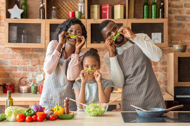 Wesoła czarna rodzina bawiąca się w kuchni - Zdjęcie, obraz
