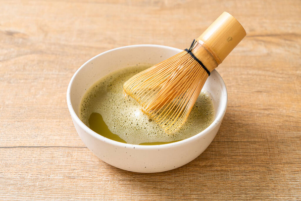 hot matcha green tea cup with green tea powder and whisk - Zdjęcie, obraz