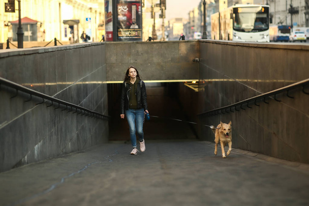 Young woman with dog at entrance of subway station - Фото, зображення