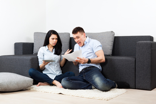 unglückliches Paar liest Brief im Wohnzimmer - Geld-Problem-Konzept - Foto, Bild