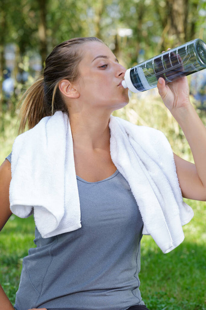 woman drinking water in between exercise - Foto, Imagem