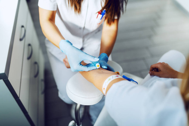 Steril lastik eldivenli laboratuvar asistanı hastadan kan örneği alıyor.. - Fotoğraf, Görsel