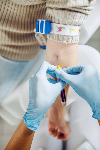 Крупный план лаборанта со стерильными резиновыми перчатками, взявшего образец крови у пациента
. - Фото, изображение
