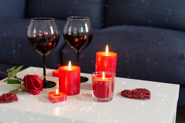 Romantikus este vörös színekben borral, rózsákkal és gyertyákkal. - Fotó, kép