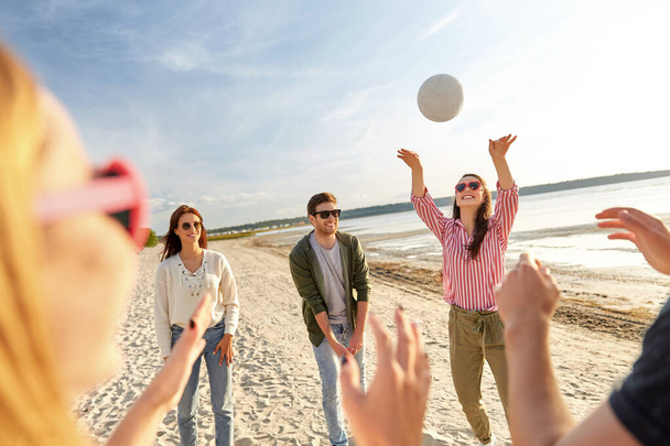 friends playing volleyball on beach in summer - Fotó, kép