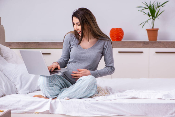 Mujer embarazada joven en el dormitorio - Foto, imagen