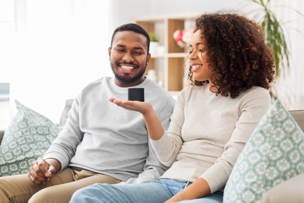 african american couple with smart speaker at home - Fotó, kép
