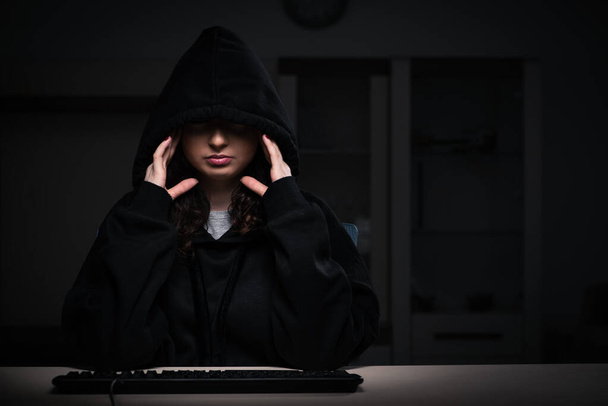 Female hacker hacking security firewall late in office - 写真・画像