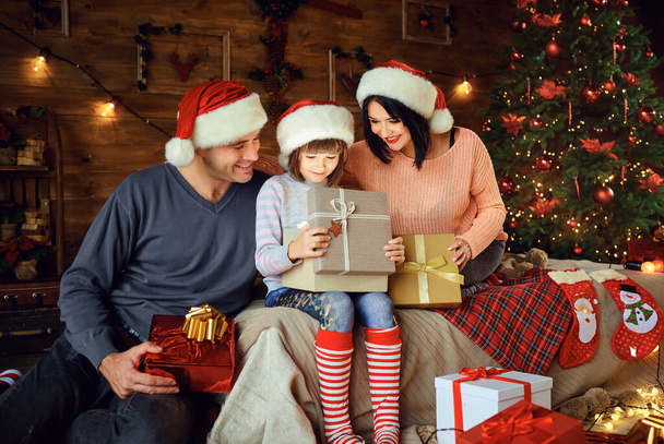 Family gives daughter a gift in the room at Christmas. - 写真・画像