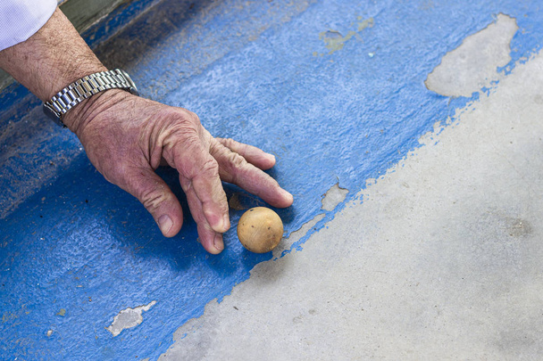 Primer plano de la sesión frontal de hombre viejo juega juego tradicional turco en concreto
 - Foto, Imagen