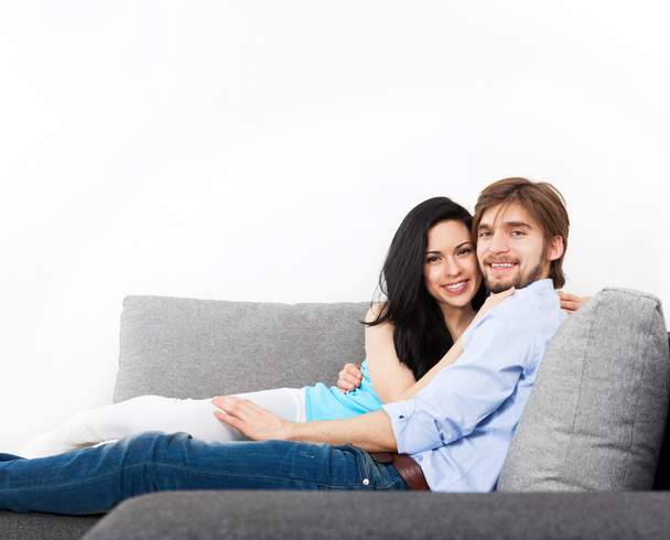 νεαρό ζευγάρι που κάθεται στον καναπέ - Φωτογραφία, εικόνα