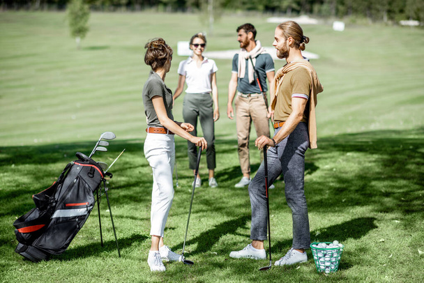 Młodzi przyjaciele na polu golfowym - Zdjęcie, obraz