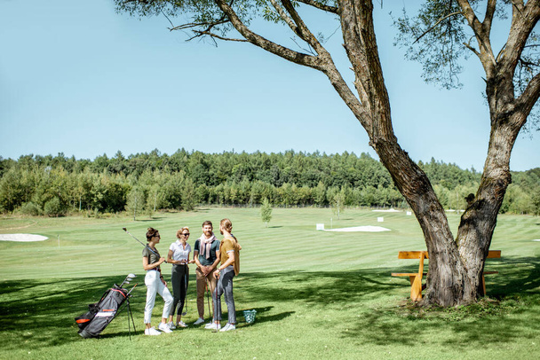 Молодые друзья на поле для гольфа
 - Фото, изображение