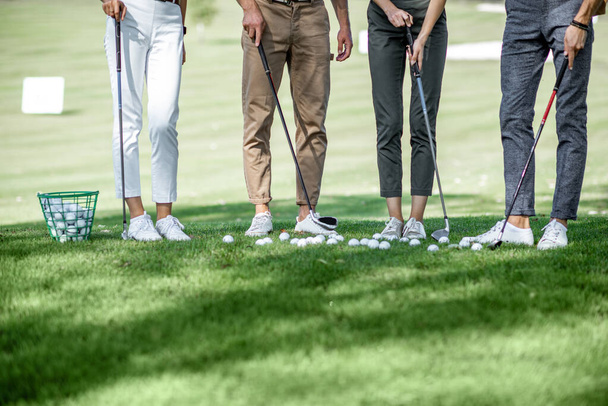 Pessoas com equipamento no campo de golfe
 - Foto, Imagem