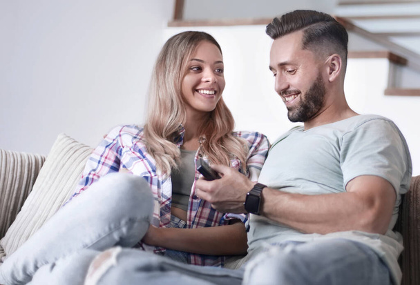 loving couple sitting on sofa in cozy living room - Photo, image