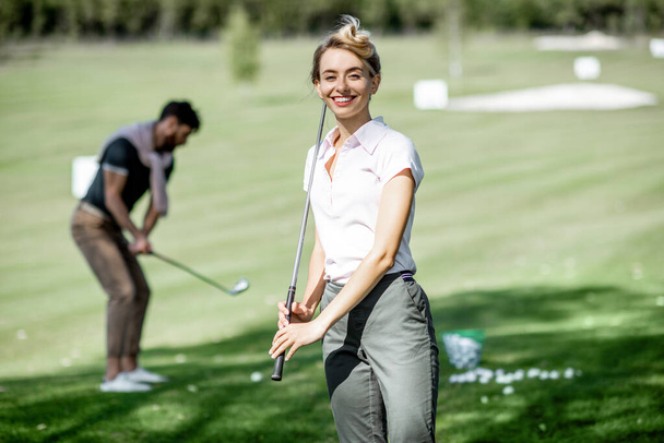 Mulher com amigos jogando golfe
 - Foto, Imagem