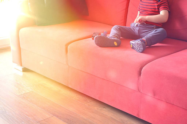 Child sitting on the sofa at home - 写真・画像