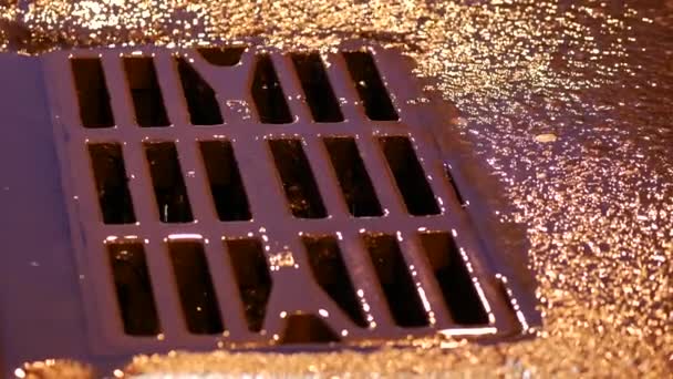 Metallgitter auf der Straße bei Regen abtropfen lassen. Roheisen rostige eiserne Lukenplatte - Filmmaterial, Video