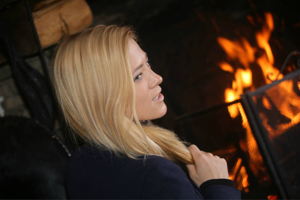  Beautiful business woman sitting near fireplace in luxurious chalet in Courchevel France. - Photo, Image