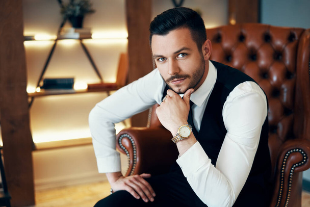 Fashion portrait of handsome young man in elegant suit in modern luxury interior - Фото, зображення