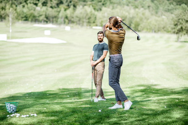 Мужчины играют в гольф на открытом воздухе
 - Фото, изображение