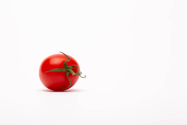 A closeup shot of a cherry tomato on a white background - perfect for a food blog - Foto, Imagem