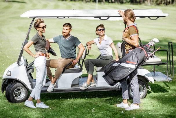 Люди біля гольф-автомобіля на ігровому полі
 - Фото, зображення