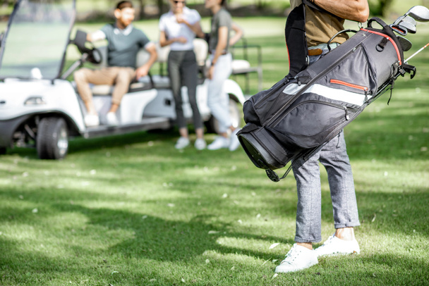 Homem com saco de golfe no campo de jogo
 - Foto, Imagem