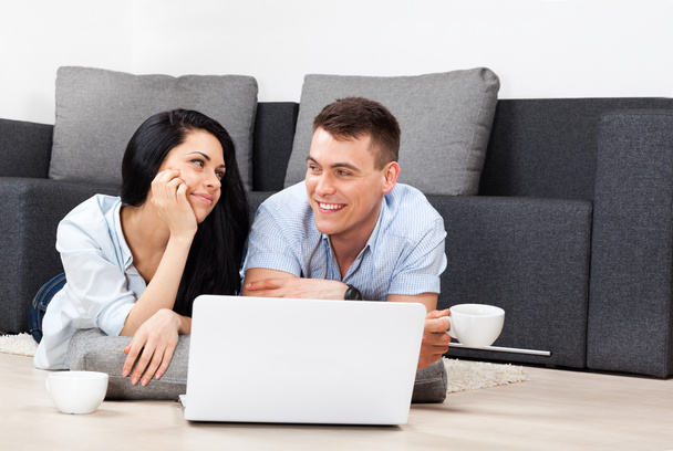 Nuori pari onnellinen smilling kannettavan tietokoneen avulla
 - Valokuva, kuva