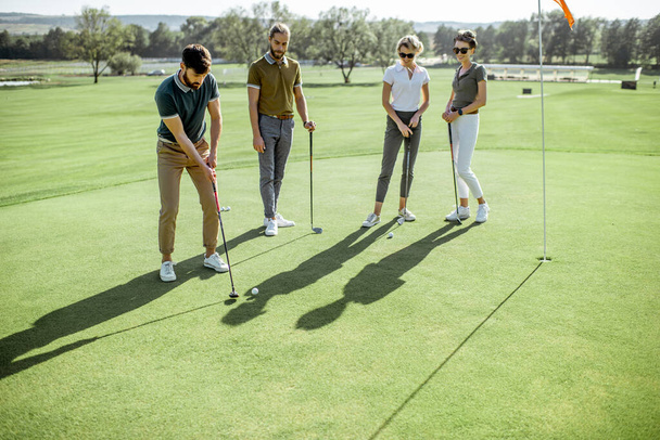Ihmiset pelaavat golfia ulkona
 - Valokuva, kuva