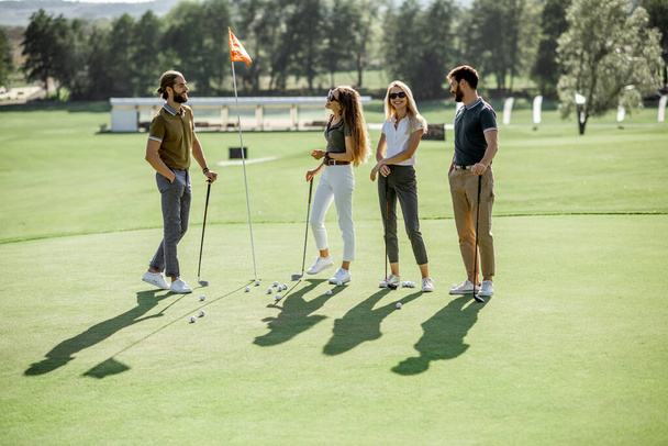 Люди играют на поле для гольфа
 - Фото, изображение