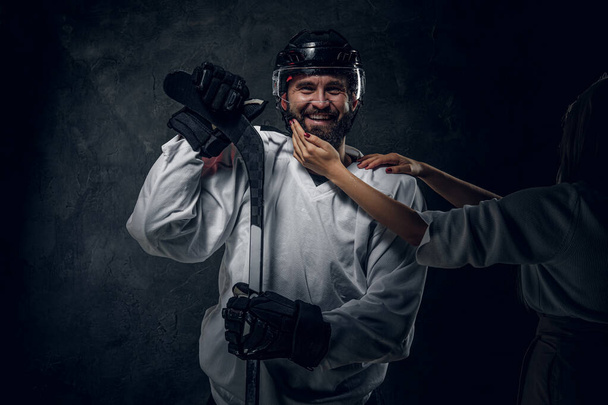 Portrait d'un joueur de hockey brutal avec la main d'une femme
 - Photo, image