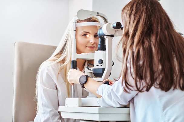 Woman Is checking her sight at optician cabinet - Фото, изображение
