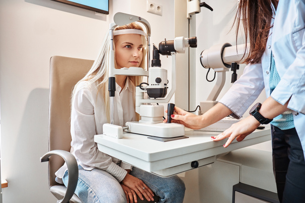 Жінка перевіряє свій зір в Оптичному кабінеті
 - Фото, зображення