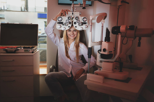 Женщина проверяет зрение в кабинете оптика
 - Фото, изображение