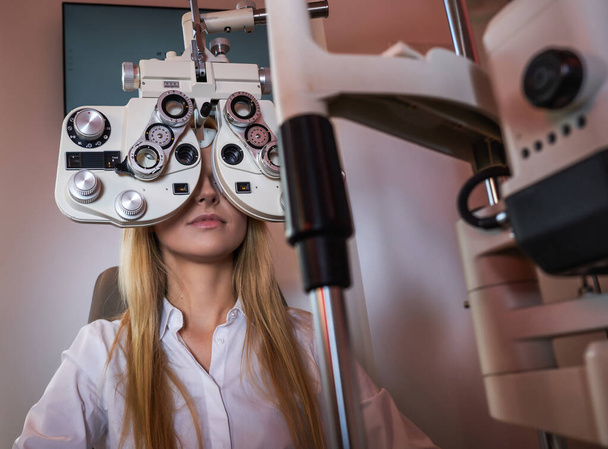 Vrouw controleert haar zicht bij opticien kabinet - Foto, afbeelding