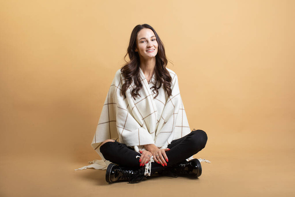 The image of a young beautiful woman in a white sweater and plaid posing on an isolated orange background shows different emotions - Foto, Bild