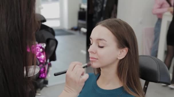 Profesional de maquillaje artista mujer agita crema de maquillaje en una paleta
. - Imágenes, Vídeo