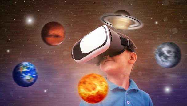 A fiú egy virtuális valóság headsetet használ, hogy tanulmányozza a bolygókat és az univerzumot. Fogalmi fotó egy fiúval és a tengelye körül keringő bolygókkal. - Fotó, kép