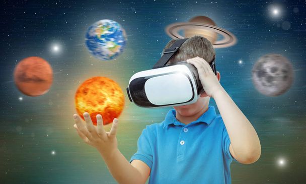 Boy studeert ruimte met behulp van technologie en de app. Hoofdtelefoon voor virtual reality. - Foto, afbeelding